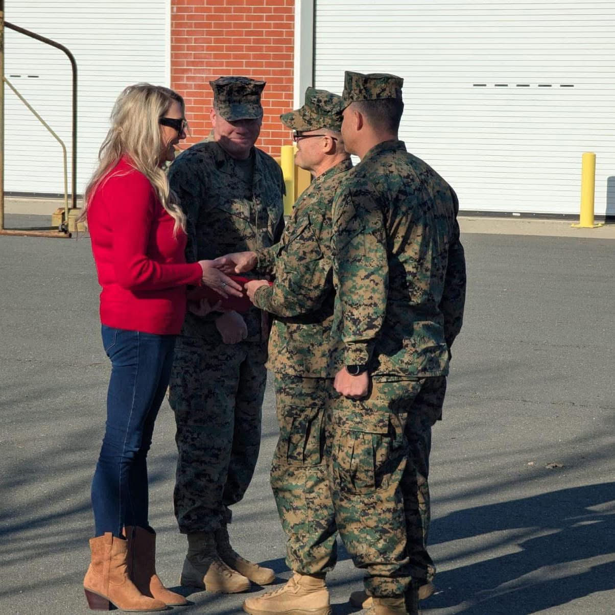 Jen in a red sweater greeting Marines