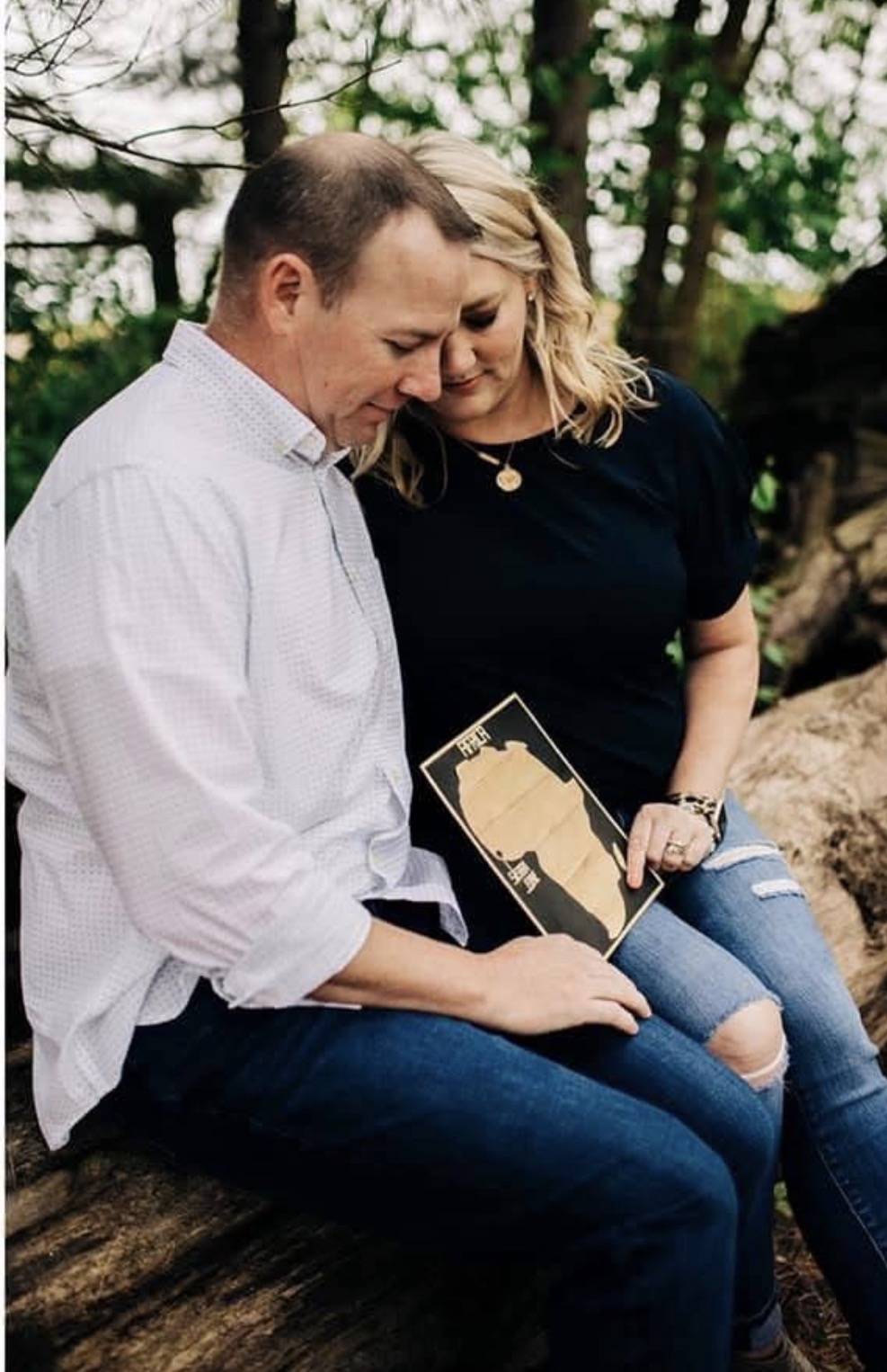 Jen and AJ holding a card with an outline of Africa